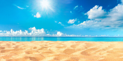 Tropical summer beach with golden sand on blurred background turquoise ocean and blue sky with white clouds on bright sunny day. Colorful landscape for summer holidays.