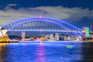 Colourful Light show at night on Sydney Harbour NSW Australia. The bridge illuminated with lasers and neon coloured lights 