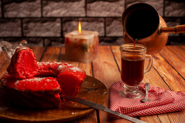 coffee with red pudding for breakfast and snack on a wooden table with the light of a candle and bronze coffee pot and glass sugar bowl