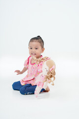 Portrait Little girl Attractive woman holds her favorite toy or pink baby doll. Cute girl looks so happy. Lovely young lady wears with isolated, white background