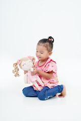 Portrait Little girl Attractive woman holds her favorite toy or pink baby doll. Cute girl looks so happy. Lovely young lady wears with isolated, white background
