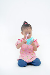 Little girl shows how to properly brush her teeth using the example of a jaw model on white background. Child demonstrates brushing his teeth. Hygiene, prevention and protection of teeth and gum.