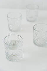 high angle view of glasses with clean water on grey blurred background.