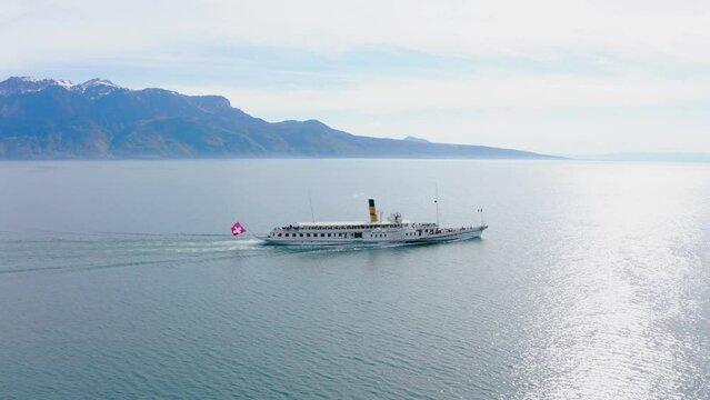 Drone shot showing wide shot of paddle steamer ferrying passengers across a lake in Switzerland.