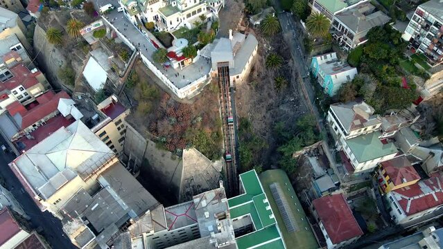 Aerial orbit of two carriages going up and down in El Peral funicular in Cerro Alegre, Valparaiso hillside city, Chile