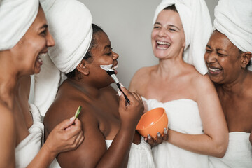 Multi generational women having fun during beauty day indoor - Mulitraical female friends enjoy spa day together