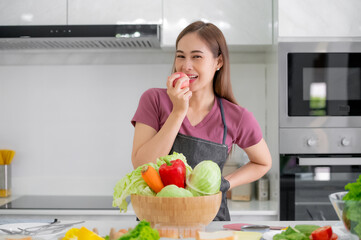 Asian women smiling in kitchen cooking salad vegetable eat healthy