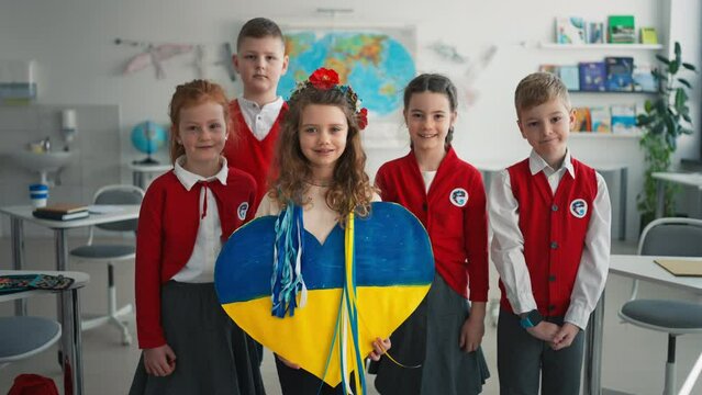 Schoolchildren welcoming new Ukrainian classmate, concept of enrolling Ukrainian kids to schools.