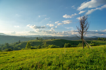 Travel photo of Ukrainian Carpathians. Scenic views of the mountain ranges during sunset, the sky with clouds and the settlements of local residents.