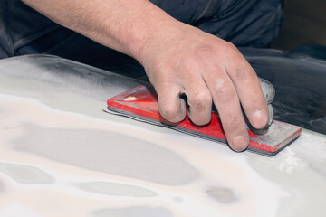 The master repairs the damaged part of the car after the accident. Body shop for car restoration.