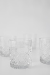 selective focus of transparent glass with water on grey blurred background.