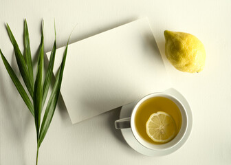 blank white invitation template, rectangle, art canvas texture, soft shadows, lemon and leaf decoration, tea cup, white background, canvas texture, photo taken from above