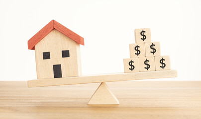 House or Property investment concept. House model and wooden blocks with dollar sign balancing on a...