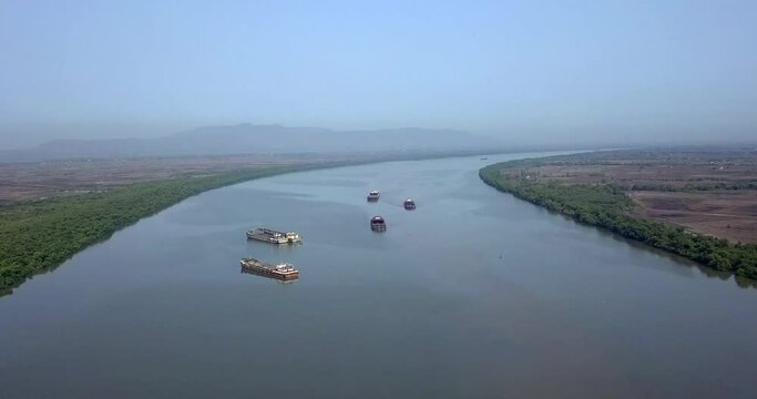 Aerial View Of Industrial Freight Vessels That Are Afloat And Sailing On The Amba River In Maharashtra, India. Wide Shot