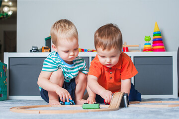 Obraz premium Two children boy play together with toys in interior of children's room..