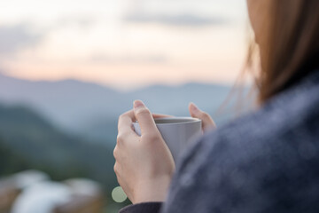 solo woman drink coffee with relax and wellbeing feel with mountain background