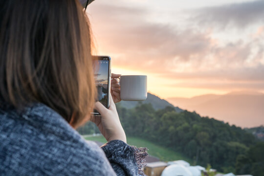 solo woman use phone take photo during drink coffee with relax and wellbeing feel with mountain background