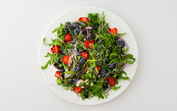 Light Salad With Arugula And Berries, Strawberries And Blueberries, Delicious Healthy Summer Salad On A White Background