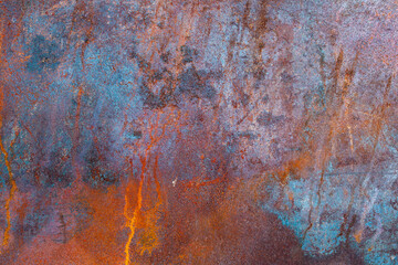 Rusted metal texture with orange and aquamarine spots. Rust surface background. Close up of rust on an old sheet of metal.