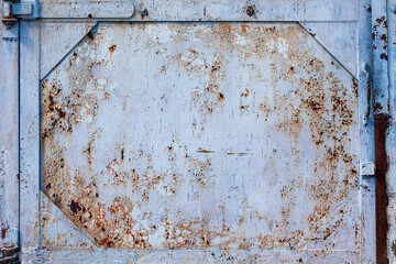 Texture of an old metal door with rust and cracked paint. Close-up of a grungy metal door with a handle. Abstract background
