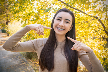 Pretty teenage girl pointing at dental braces