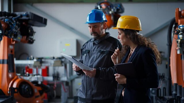 Female engineering manager and mechanic worker doing routine check up in industrial factory