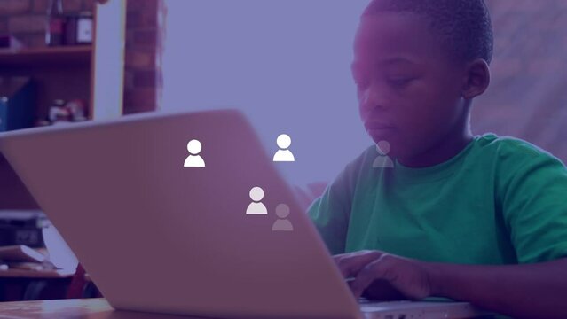 Animation of social medial icons over happy african american boy using laptop at school