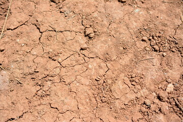 red dry earth with cracks and stones, close-up