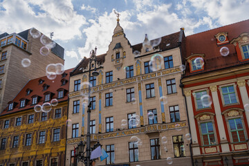 Fototapeta na wymiar Low angle view of blurred soap bubbles on urban street in Wroclaw