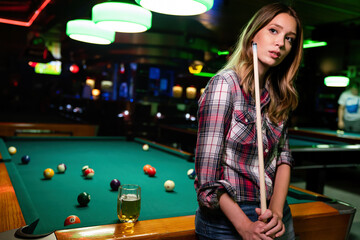 Portrait of beautiful young woman in billiard club