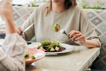 Close Up of Unrecognisable Women Having Lunch Meeting, Eating Salad in the Restaurant 