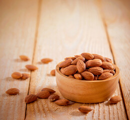 Almonds seed in the wooden bowl on the wooden table.