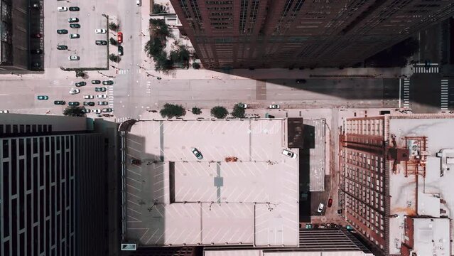 cinematic top down bird eye view of a intersection in chicago downtown on top of streets, open parking lot  while cars drivers