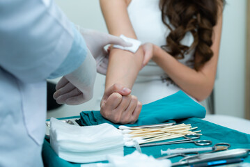 Hand of Caucasian male doctor in white medical gloves using a piece of cotton pad press on the...