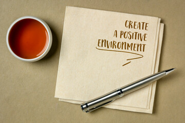 create a positive environment, inspirational reminder note on a napkin with a cup of tea, healthy lifestyle concept