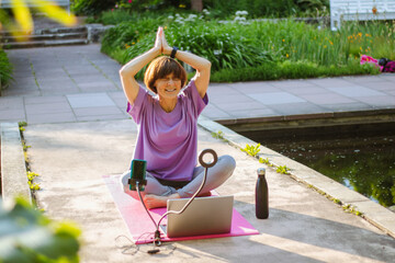 An old slender woman does yoga in the park online