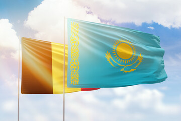 Sunny blue sky and flags of kazakhstan and belgium
