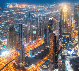 Aerial View Of Urban Background Of Illuminated Cityscape With Skyscrapers In Dubai. Street Night Traffic In Dudai Skyline. Moving through modern city street with illuminated. UAE, United Arab Emirates