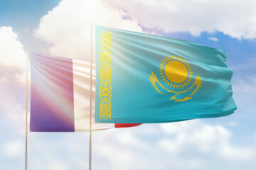 Sunny blue sky and flags of kazakhstan and france