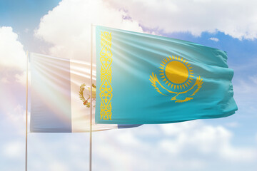 Sunny blue sky and flags of kazakhstan and guatemala