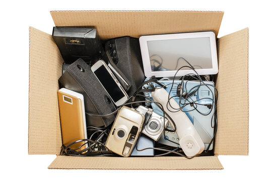 Old Electronic Devices In A Cardboard Box. The Concept Of Recycling And Disposal Of Electronic Waste. Isolated On White