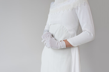 cropped view of woman in gloves and wedding dress isolated on grey.