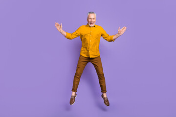 Fototapeta na wymiar Full size photo of mature cheerful man have fun jump up dream travel isolated over purple color background