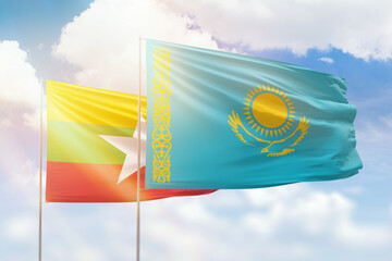 Sunny blue sky and flags of kazakhstan and myanmar
