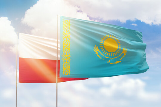 Sunny blue sky and flags of kazakhstan and poland