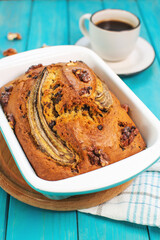 Banana bread or cake with chocolate and walnuts with cup of coffee. Delicious homemade dessert or morning breakfast.