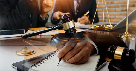 Justice and law concept.Male judge in a courtroom with the gavel, working with, computer and...