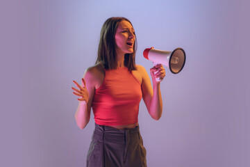 Fototapeta na wymiar Excited young beautiful girl shouting at megaphone isolated on gradient blue pink neon background. Concept of emotions, facial expression, ad