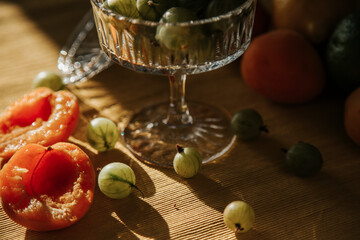 Juicy green gooseberries are lying on the table, served berries, berry snack or breakfast, vintage retro plate with gooseberries in the sun, summer local berries