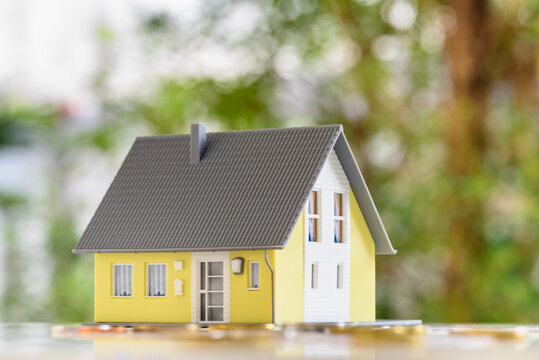 Mortgage loan or home equity loan, financial concept : Model residential house and coins or money on a table, depicting home loan or borrowing money to purchase a new home for first time homebuyer.